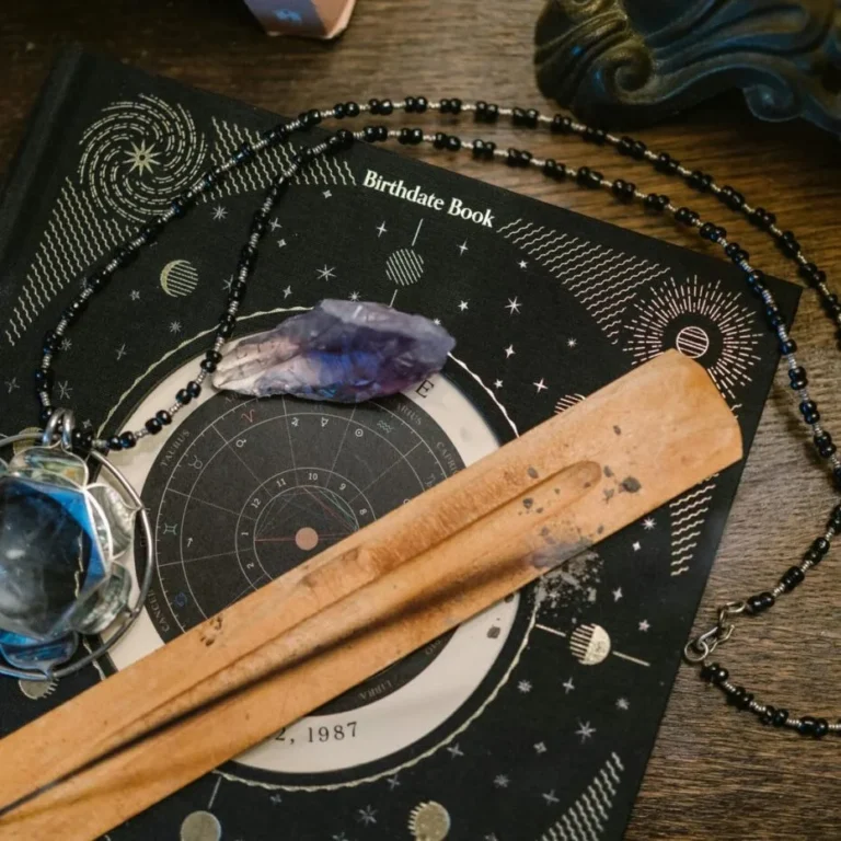 Palo santo en een kristal op een donker sterrenbord met een kralensnoer