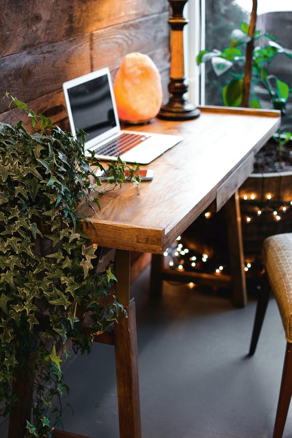 Werkplek met laptop en zoutlamp tussen groene planten