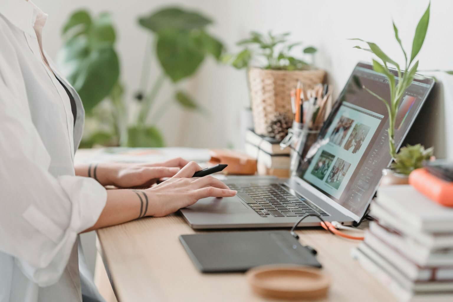 Vrouw werkt aan een laptop op een werkplek vol planten