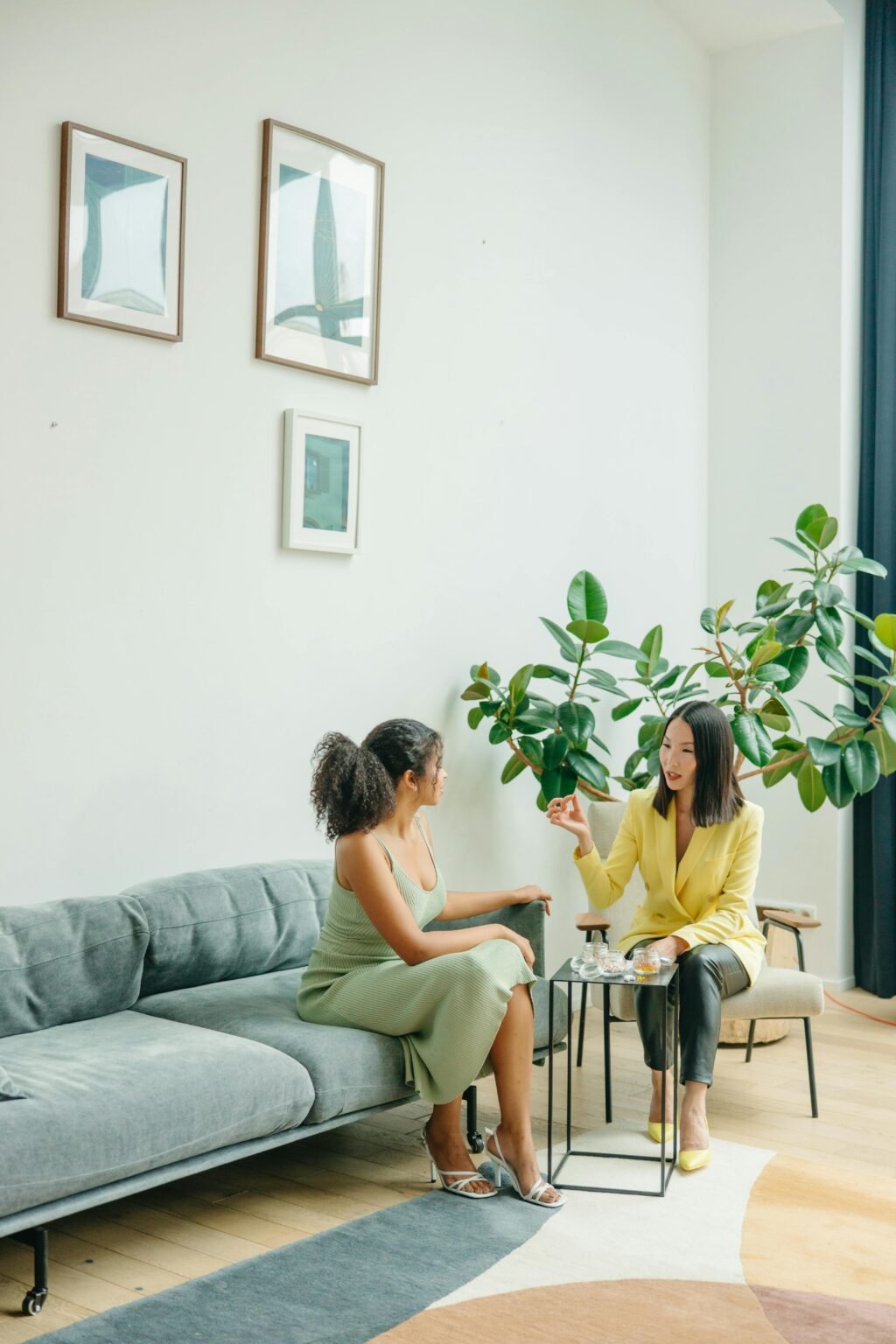Twee vrouwen in gesprek in een lichte woonkamer