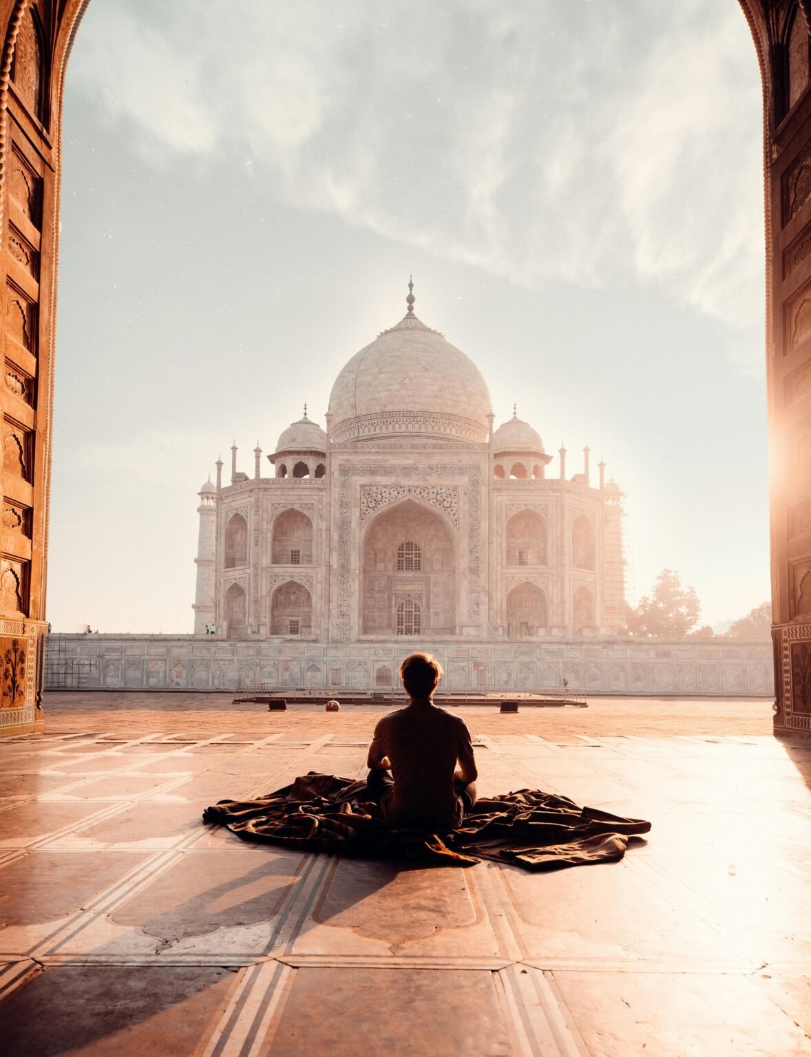 Mediterend persoon voor de Taj Mahal in ochtendlicht