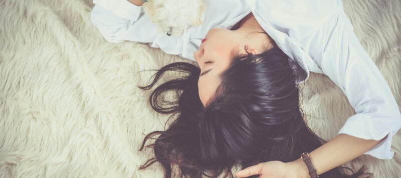 Vrouw slaapt ontspannen op een zacht kleed