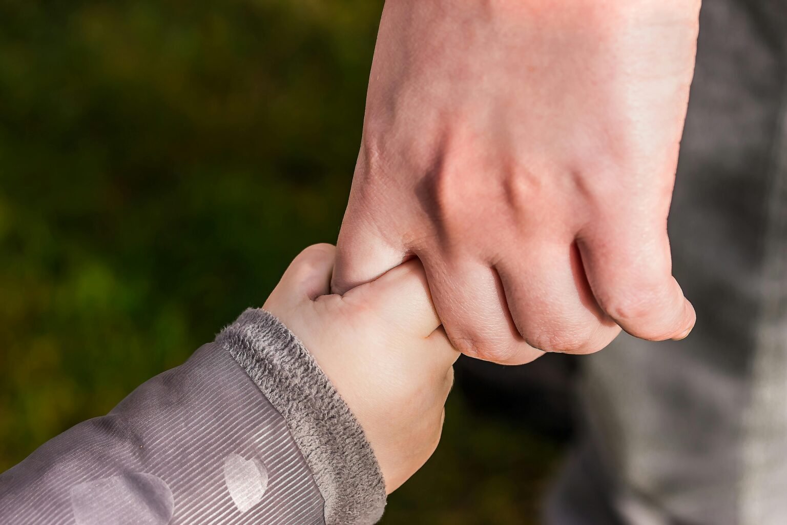Kinderhand houdt de hand van een ouder vast