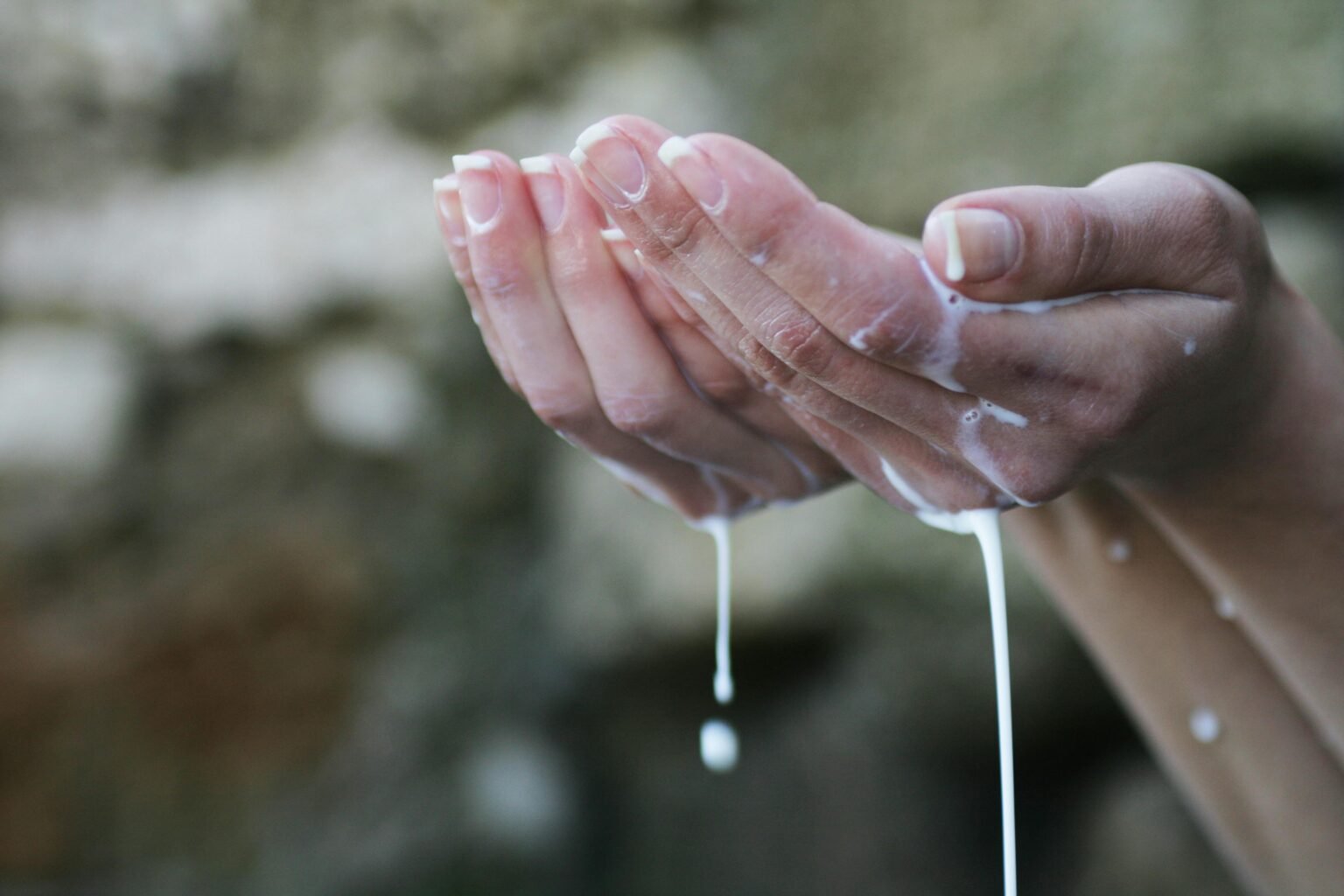 Twee handen vangen stromend water op in een ritueel gebaar
