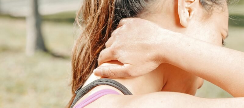 Vrouw wrijft over haar gespannen nek en schouders
