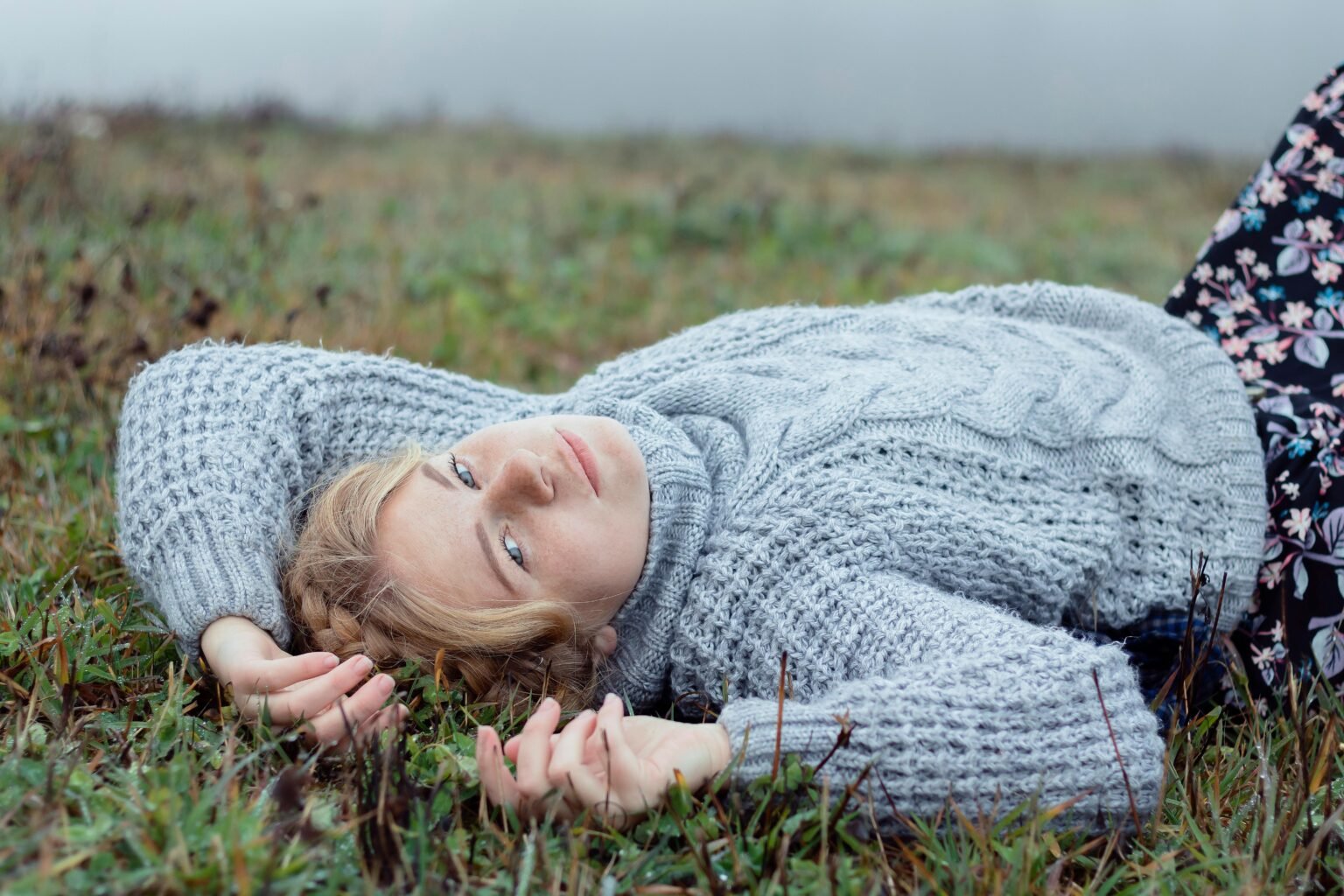 Vrouw ligt met gesloten ogen in het gras