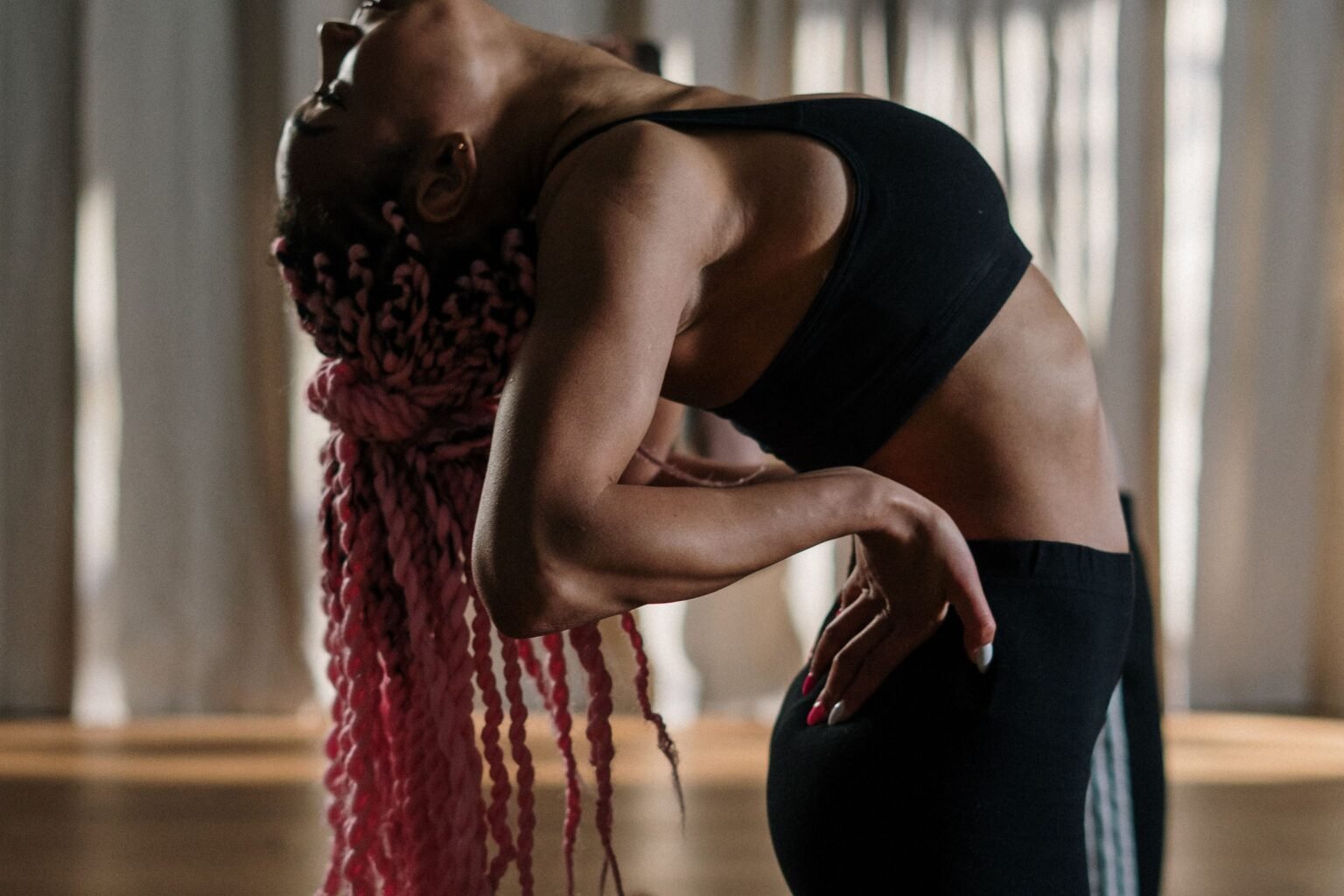 Vrouw in een diepe zijwaartse buiging in een lichte yogastudio