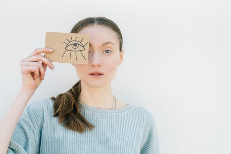 Vrouw houdt een kaart met een getekend oog voor haar gezicht
