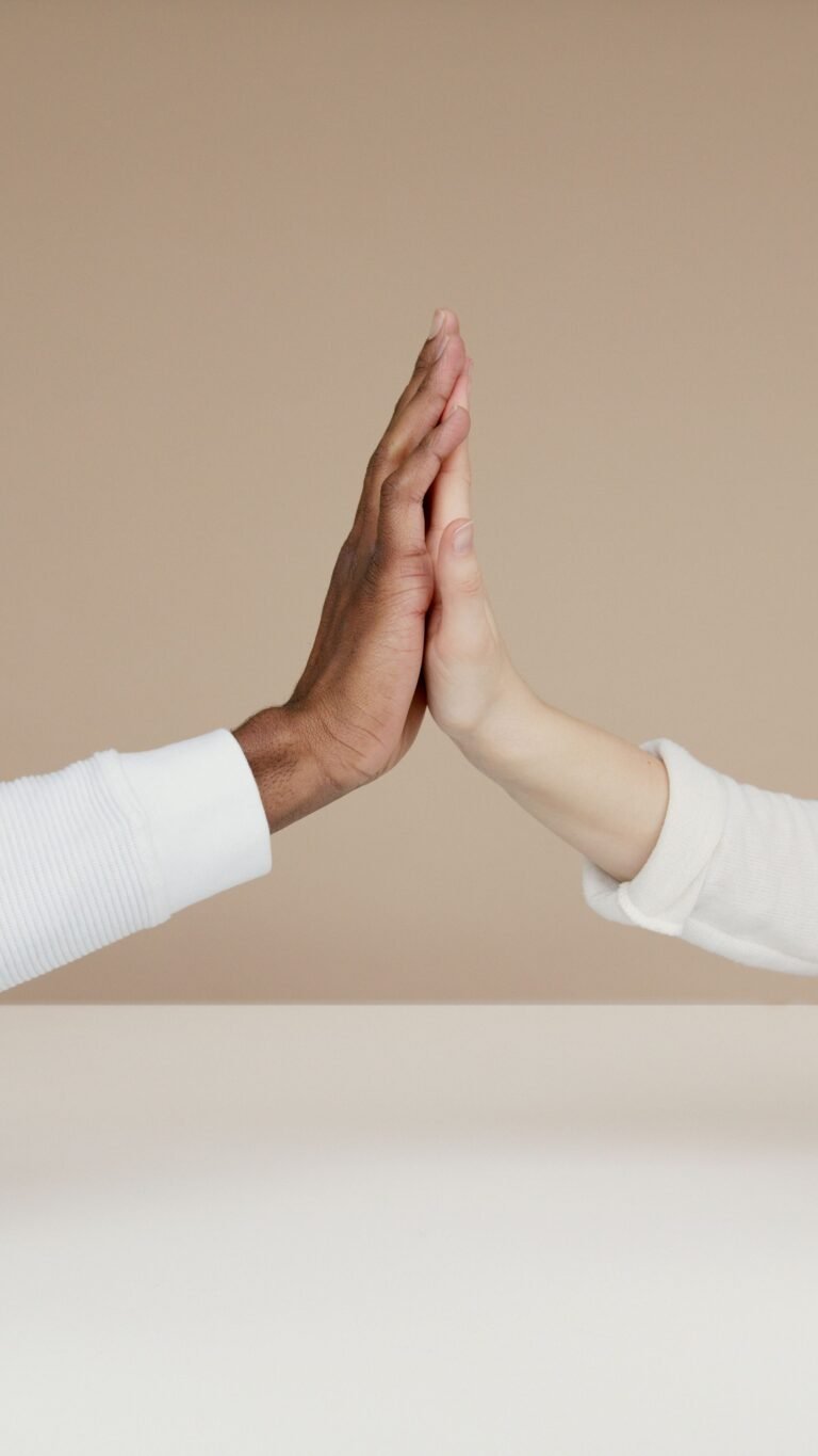 Twee handen met de handpalmen tegen elkaar, tegen een zandkleurige achtergrond