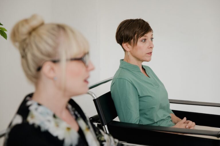 Twee vrouwen zitten tegenover elkaar tijdens een begeleidingsgesprek